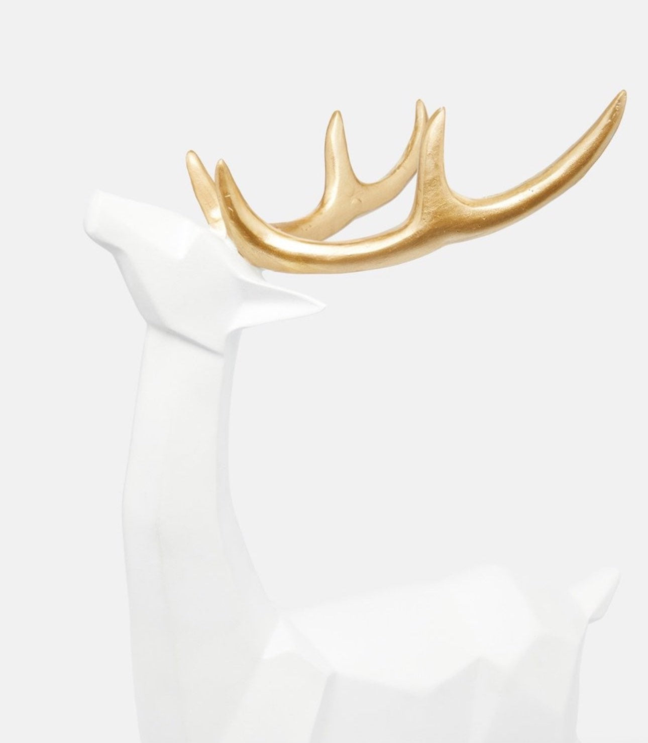 Close-up of gold antlers on modern white deer sculpture